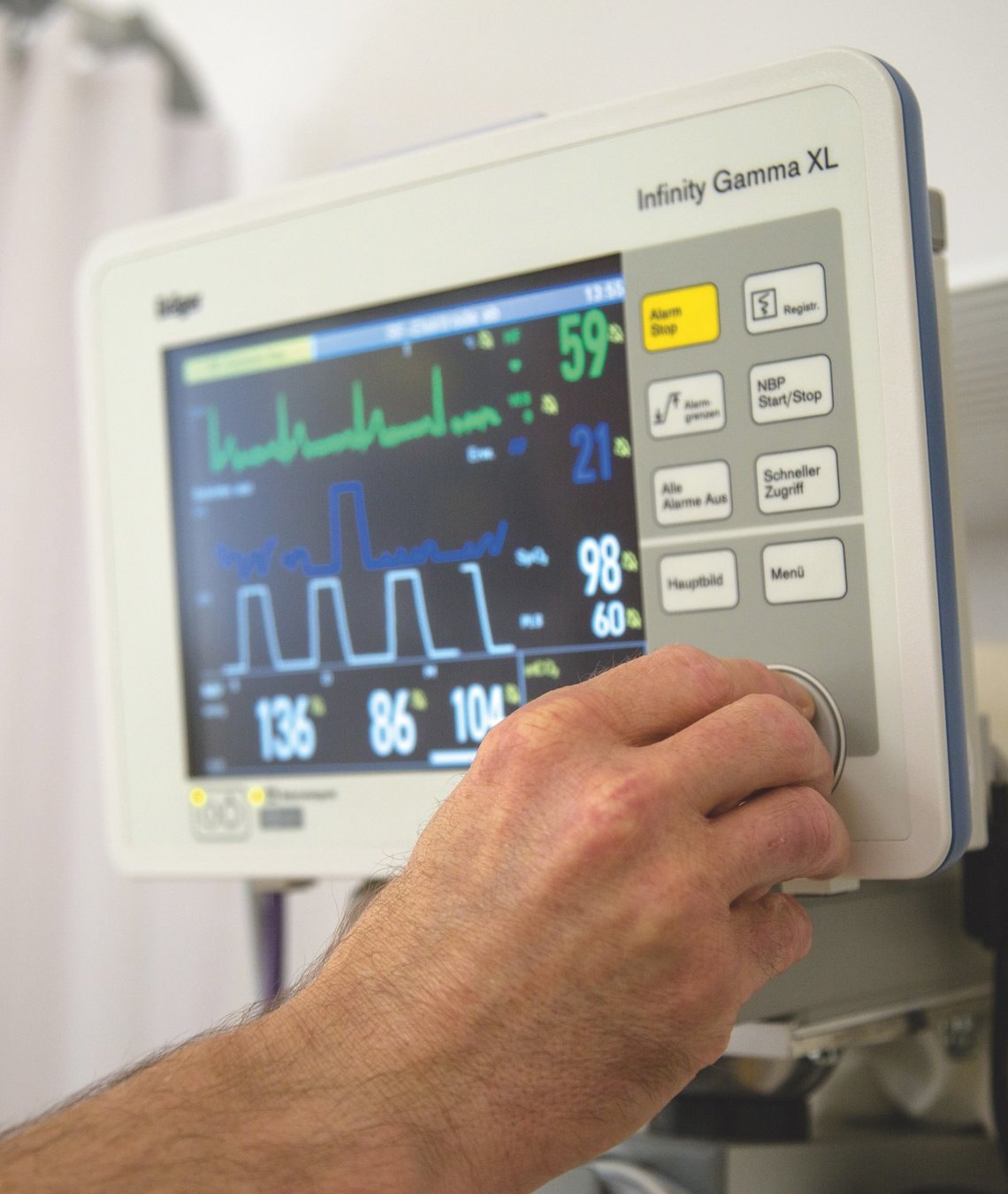 Blick auf einen Monitor, eine Pflegekraft bedient diesen