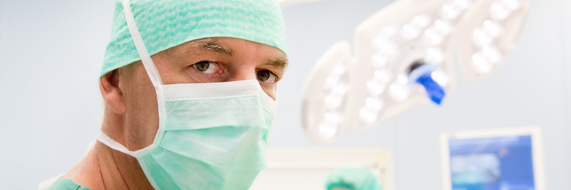 Facharzt in OP Kleidung schaut in die Kamera