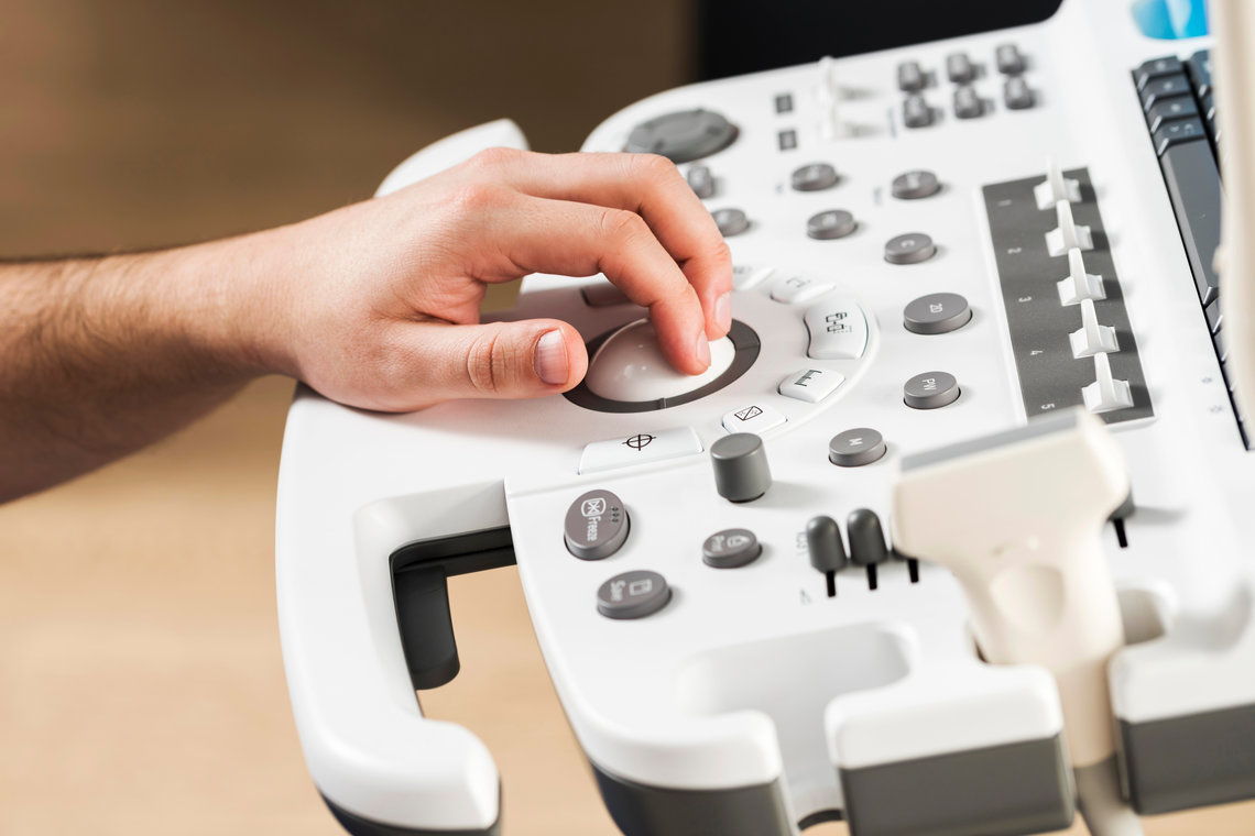 Eine Hand bedient ein Ultraschallgerät