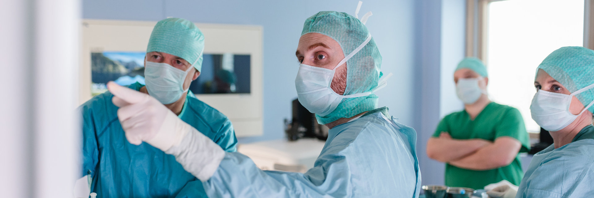 Ärzte gucken beim OP auf den Bildschirm zusammen