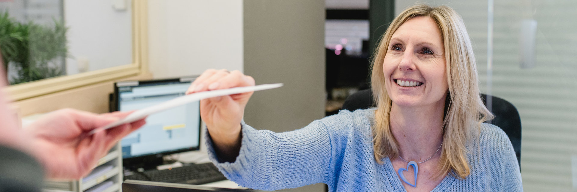 Frau an der Rezeption nimmt neuen Patienten auf